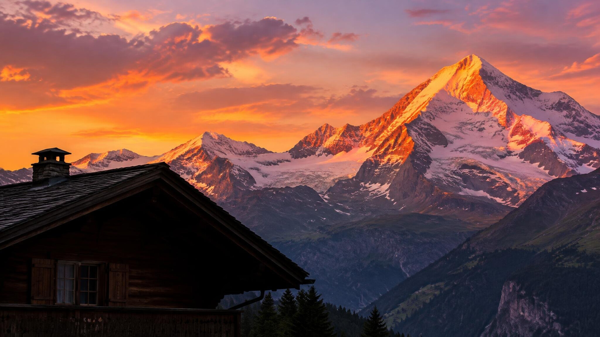 Swiss alpine mountains at sunset with a wooden chalet silhouette
